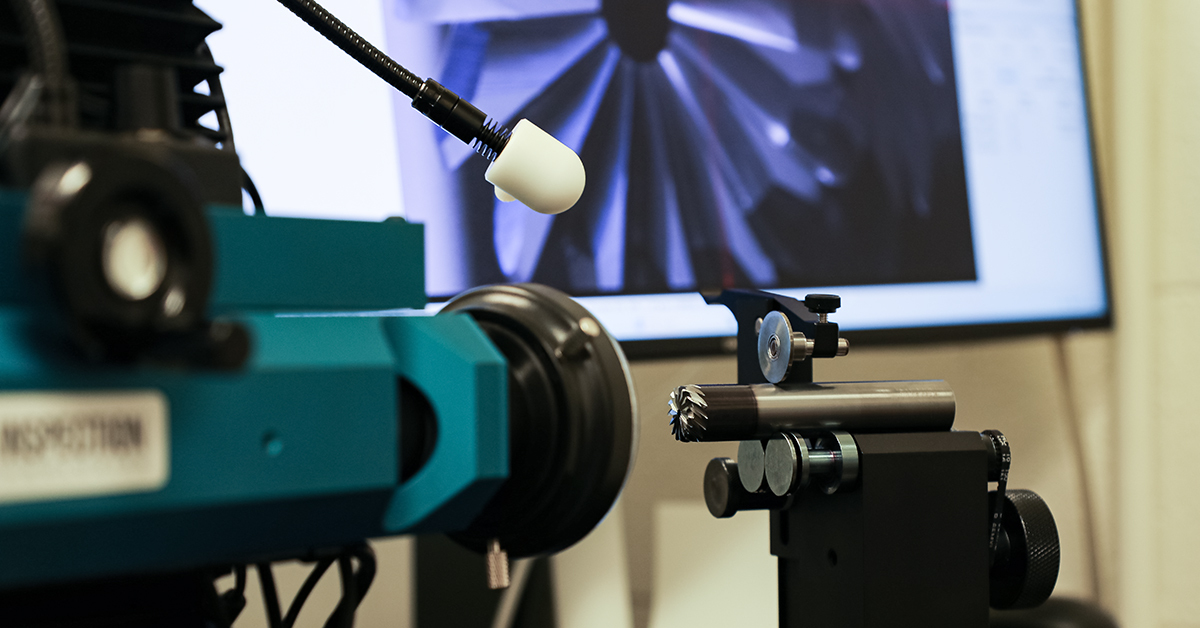 A carbide end mill being measured on inspection equipment, with the tool profile shown on screen.